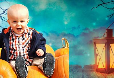 Toddler sat on pumpkins with creepy background