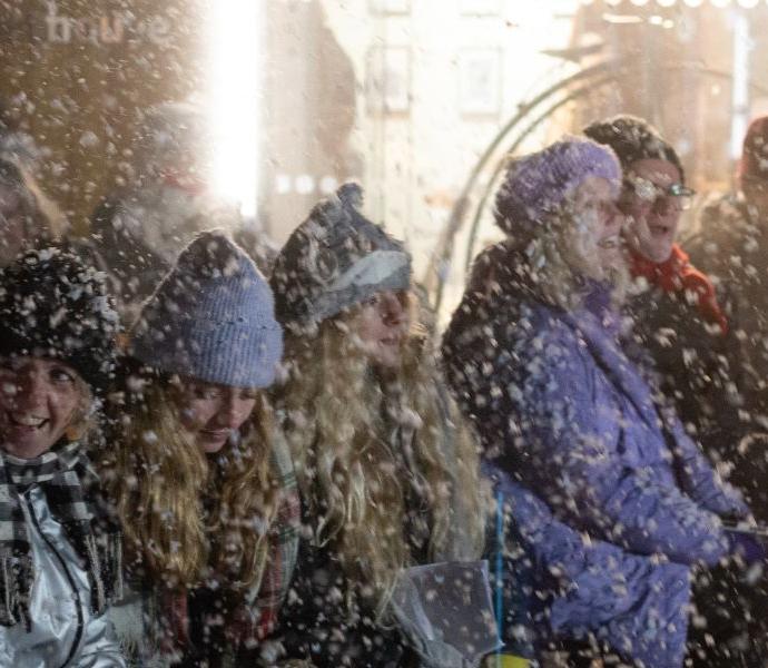 Audience sat in snow singing carols