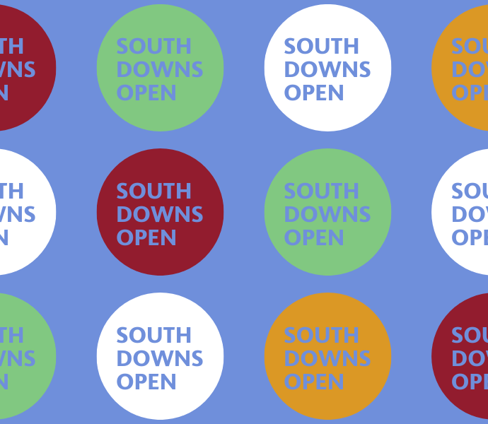 South Downs Open in yellow, red, green and white circles with blue background banner