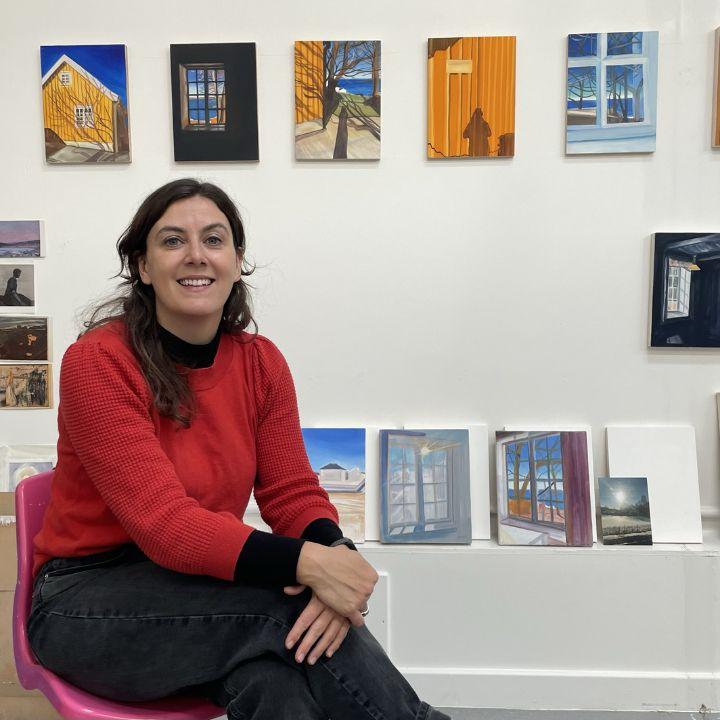 Catherin Knight in a gallery in front of her art works