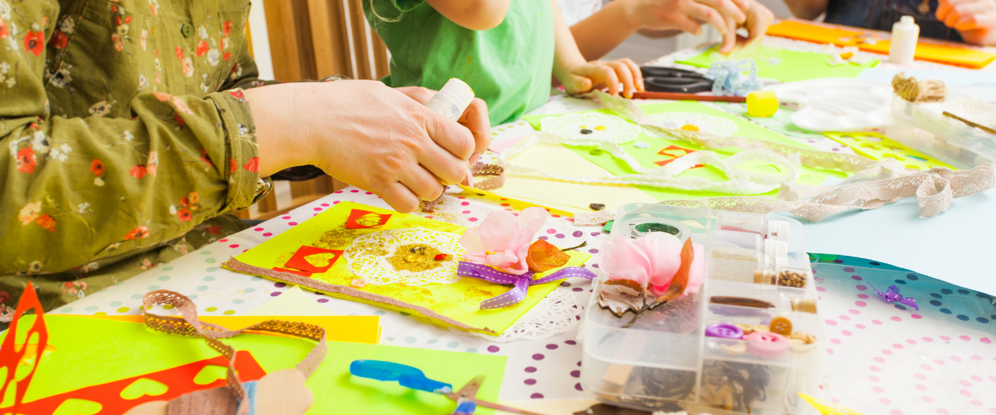 Family creating collages with paper, silk flowers, lace and ribbon.