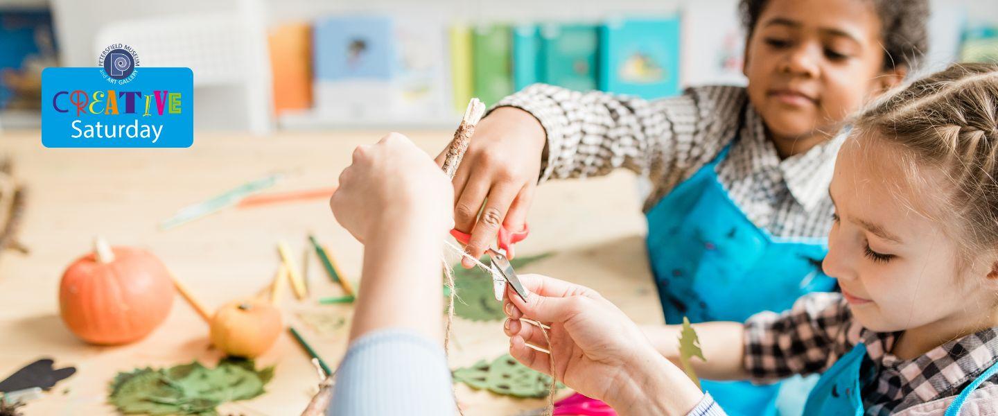 two children taking part in a craft activitiy.