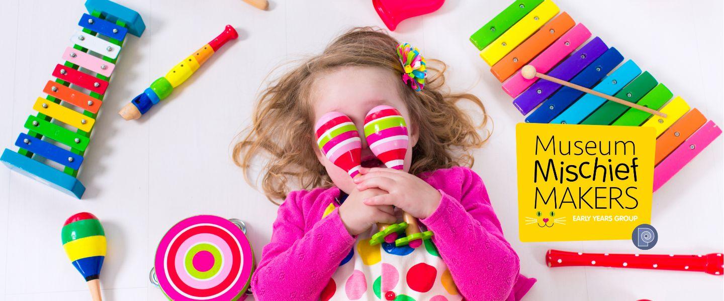 Toddler surrounded by musical instruments