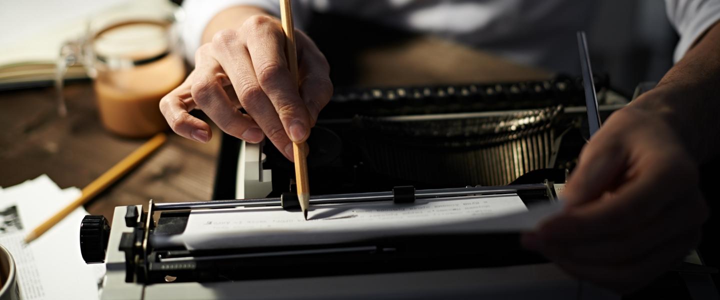 Writer editing their work from a typewriter