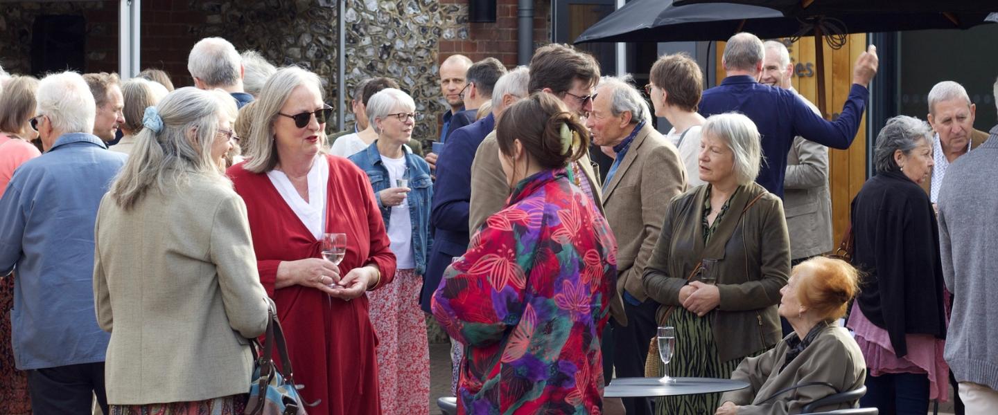 Guests gathered chatting in the courtyard of Petersfield Museum and Art Gallery