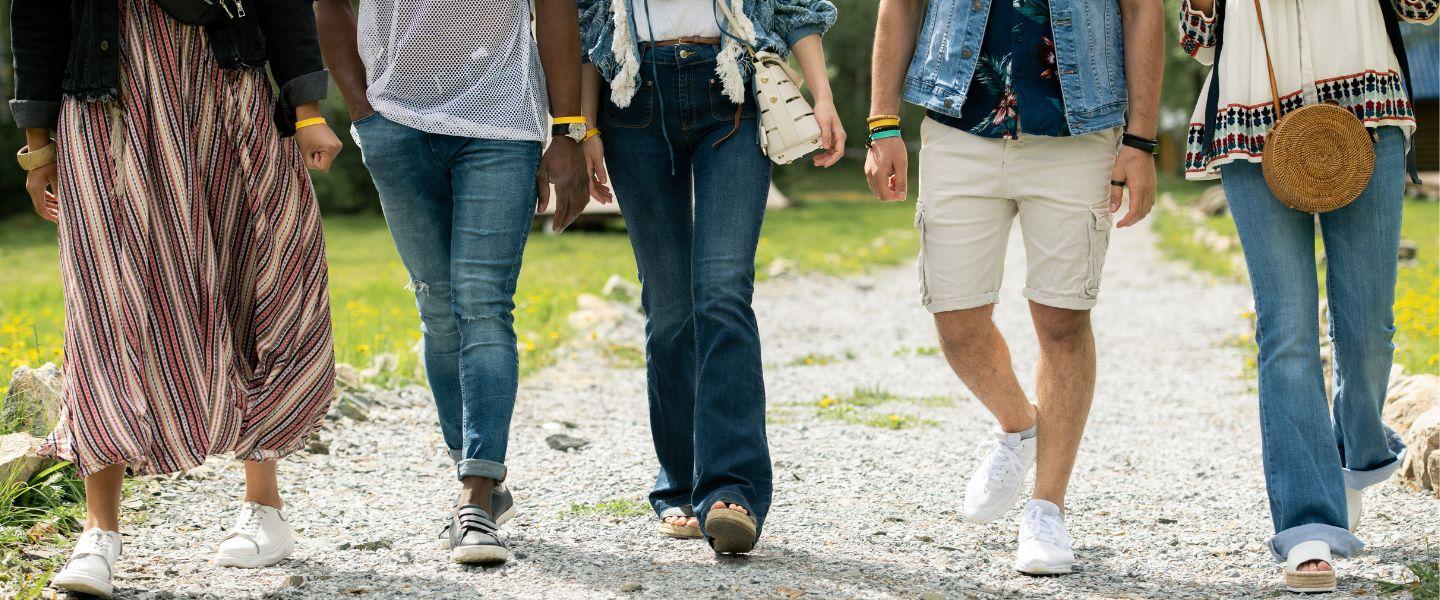 Five people walking from waist down. 