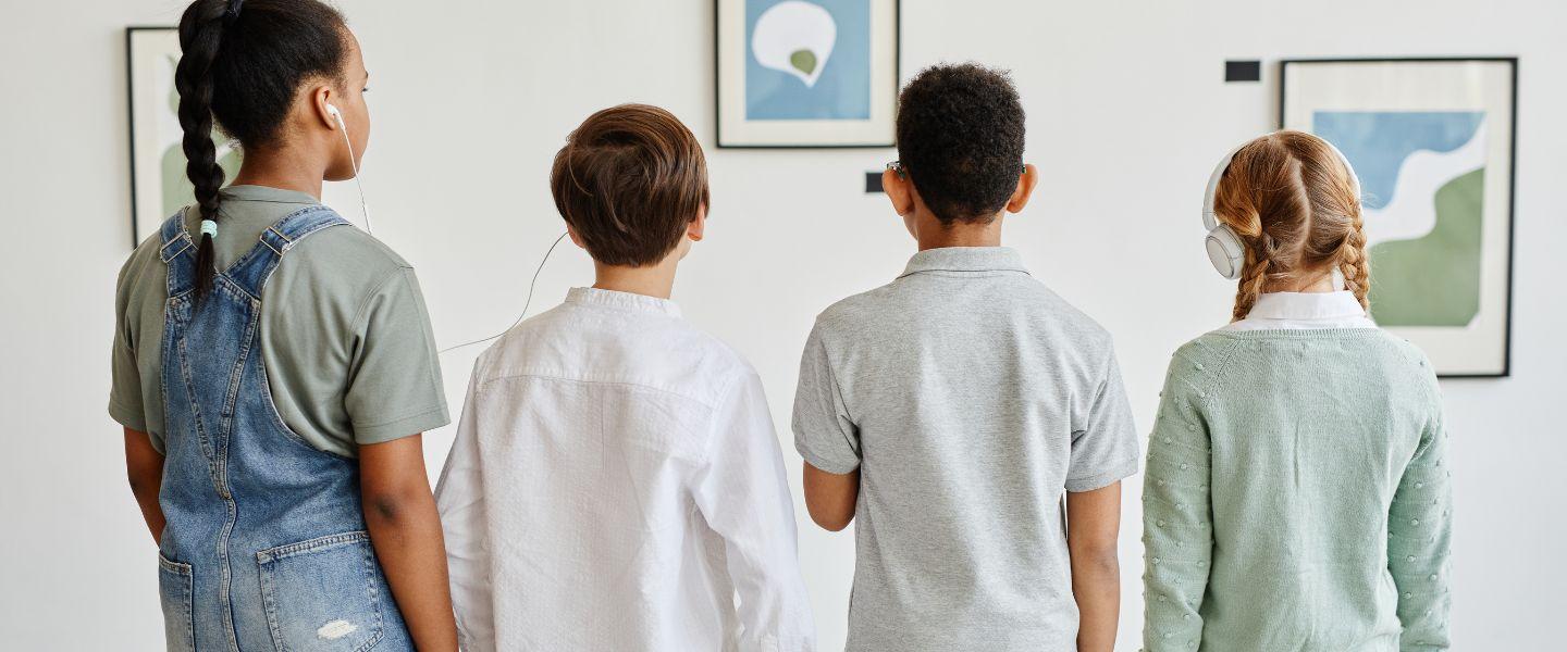 4 children in front of three pics of art work