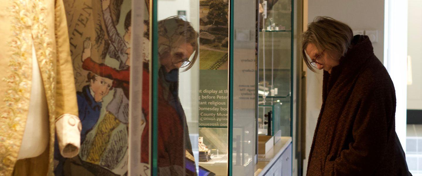 Lone woman looking into glass case